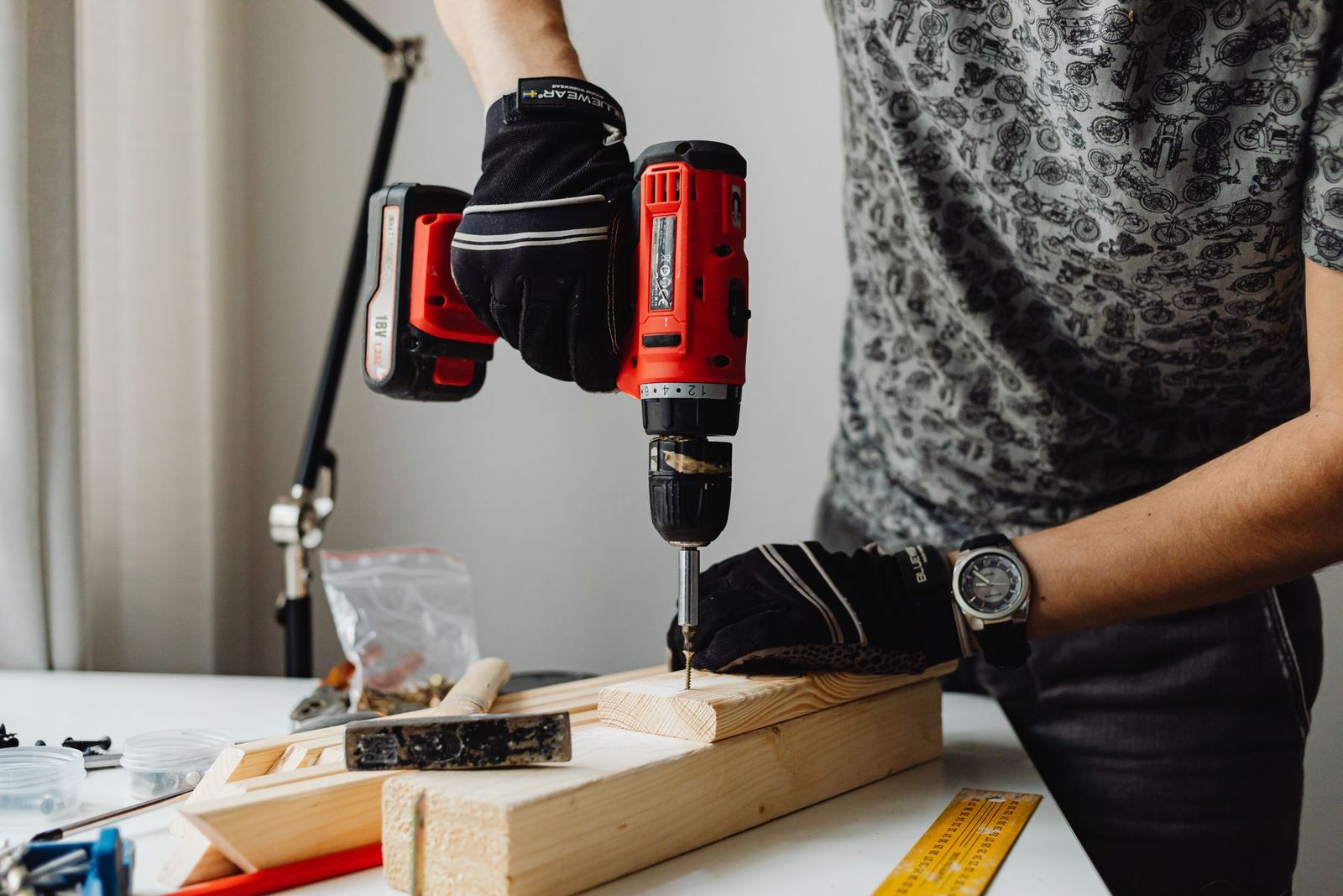 Handwerker arbeitet mit dem Akkubohrer an einem Holzteil